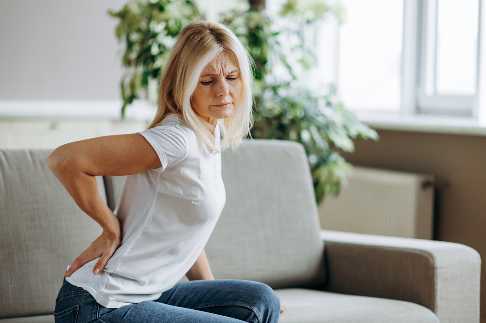 woman grabbing back from muscle cramps