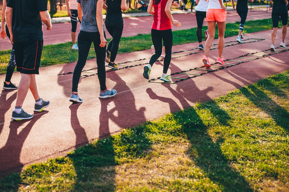 women doing agility ladder drills outdoors