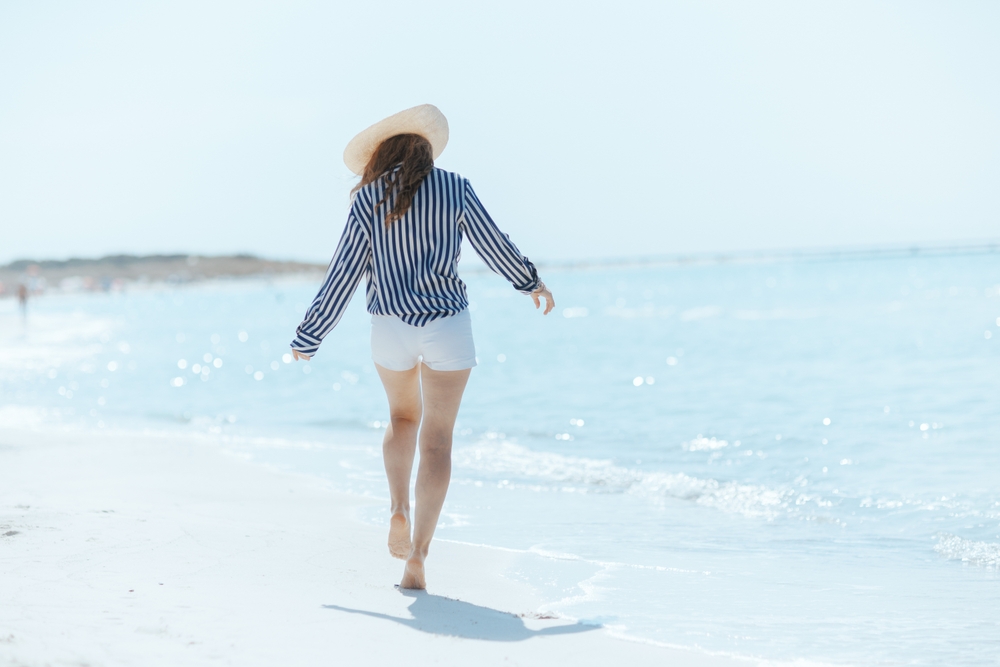 woman walking on beach getting vitamin d