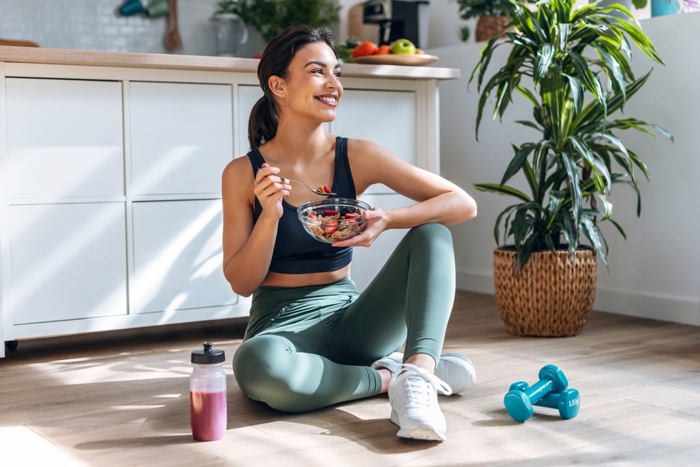 woman sitting on floor eating healthy protein