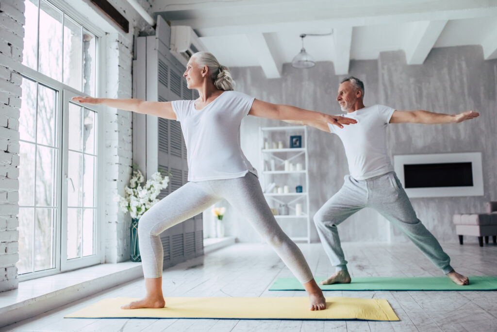 Senior couple doing yoga for healthy aging.