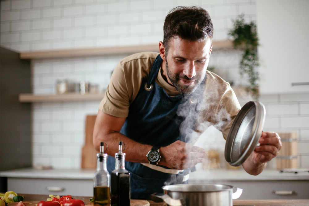 healthy man cooking food in kitchen