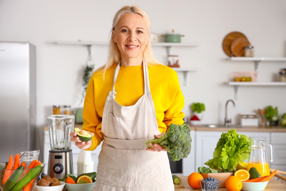 woman eating magnesium rich avocado in kitchen