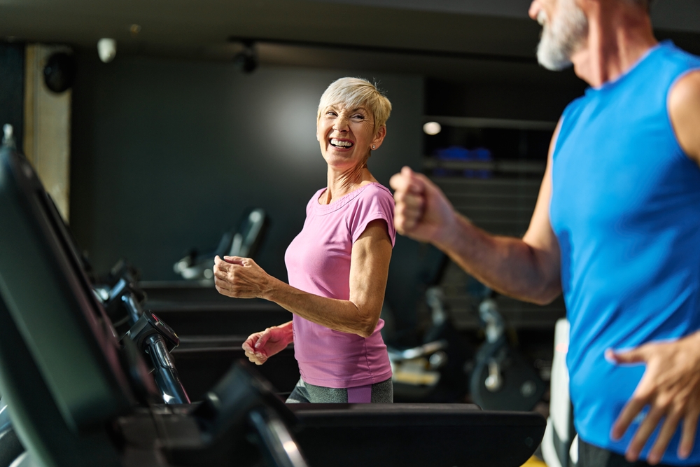 Older couple working out on treadmills.