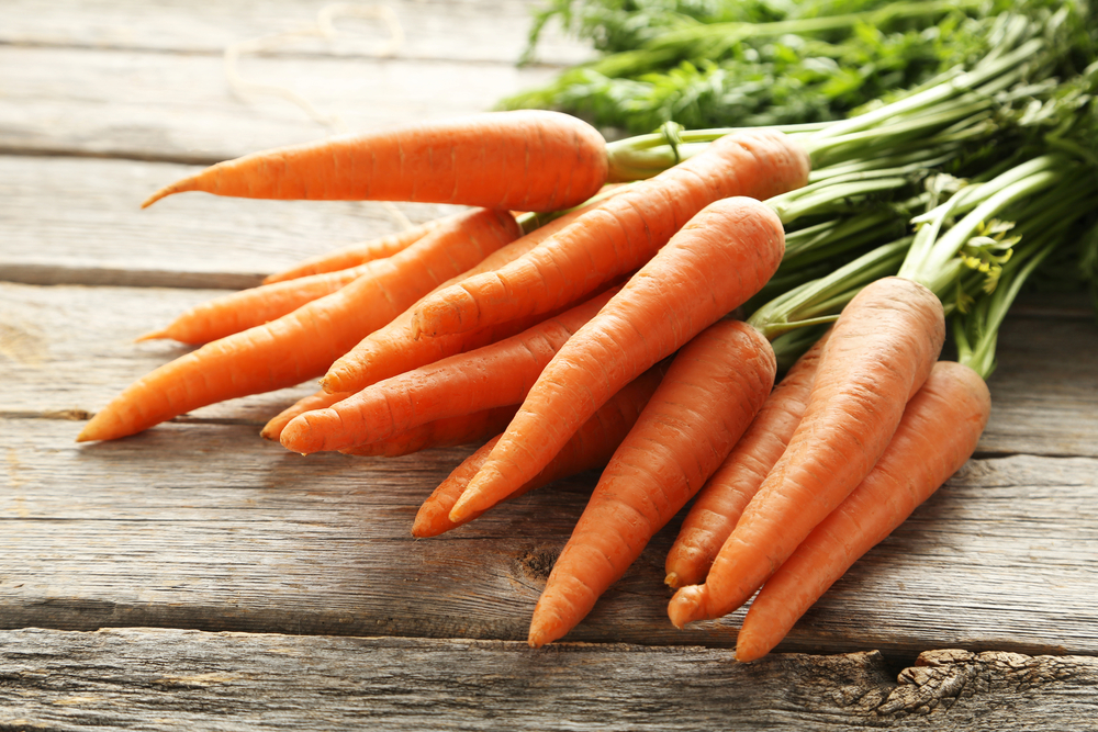 Fresh carrots on a wooden table.