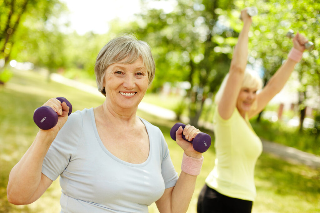 Older women doing HIIT exercises outdoors.