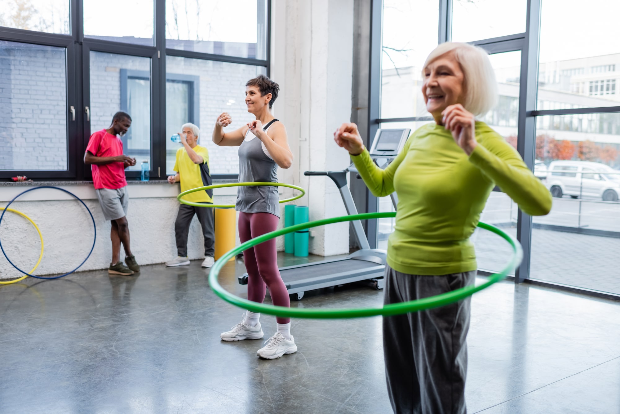 A group of older women and men doing a weighted hula hoop workout.