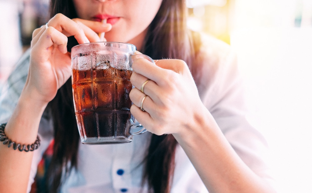 Closeup of a woman drinking soda.