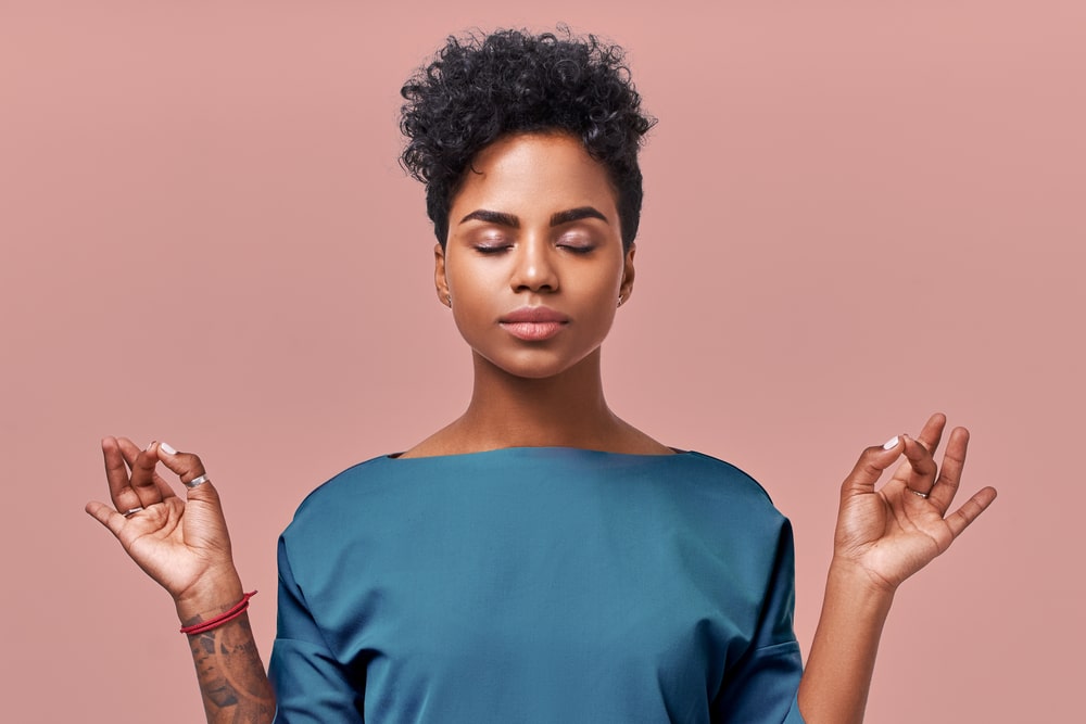 A calm woman meditating with her eyes closed.