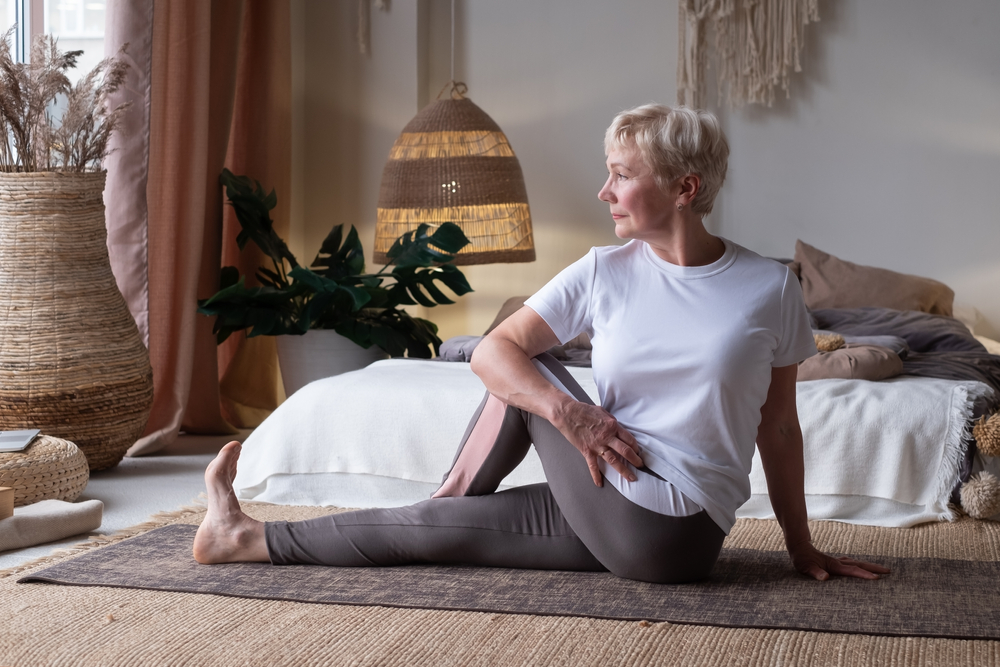 Senior woman doing a seated stretch to ease sciatica pain.