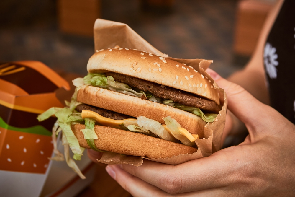 A hand holding a fast food burger.