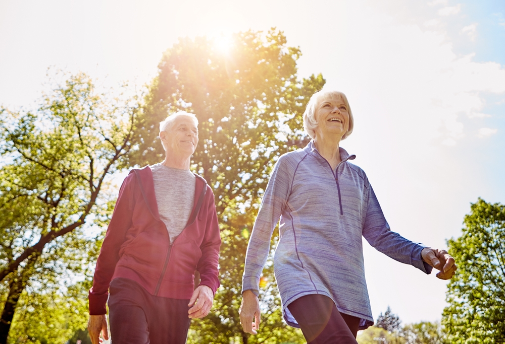 Senior couple walking in the park on a sunny day.