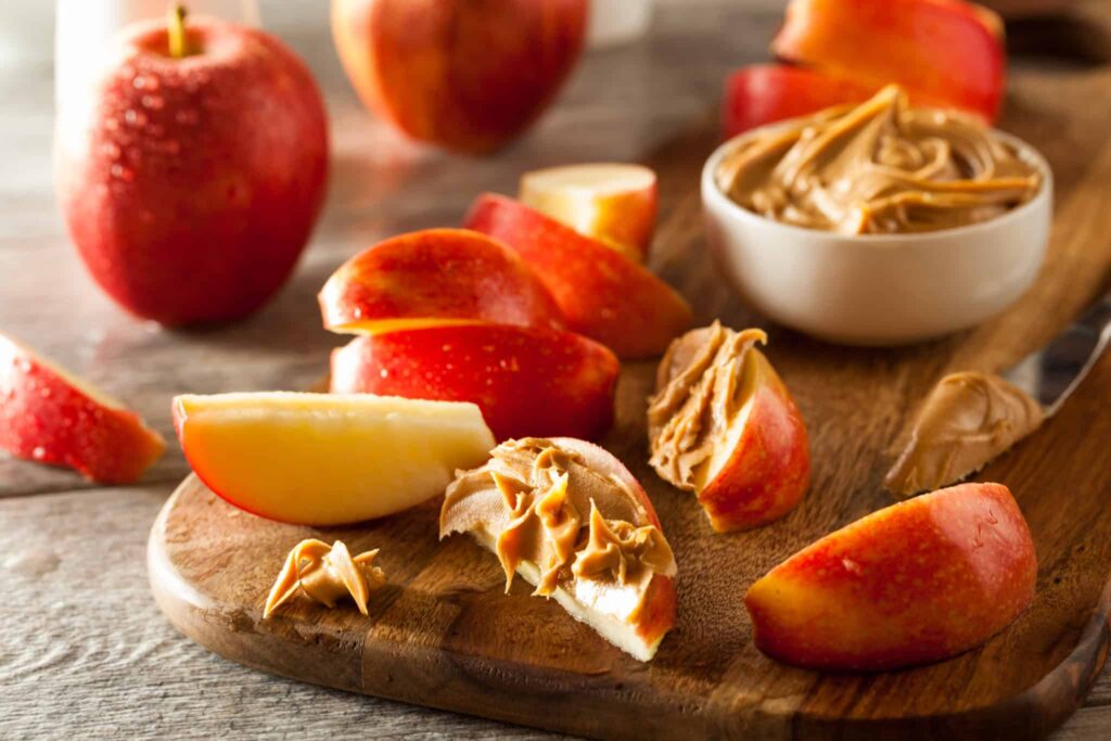 Sliced apples topped with peanut butter.