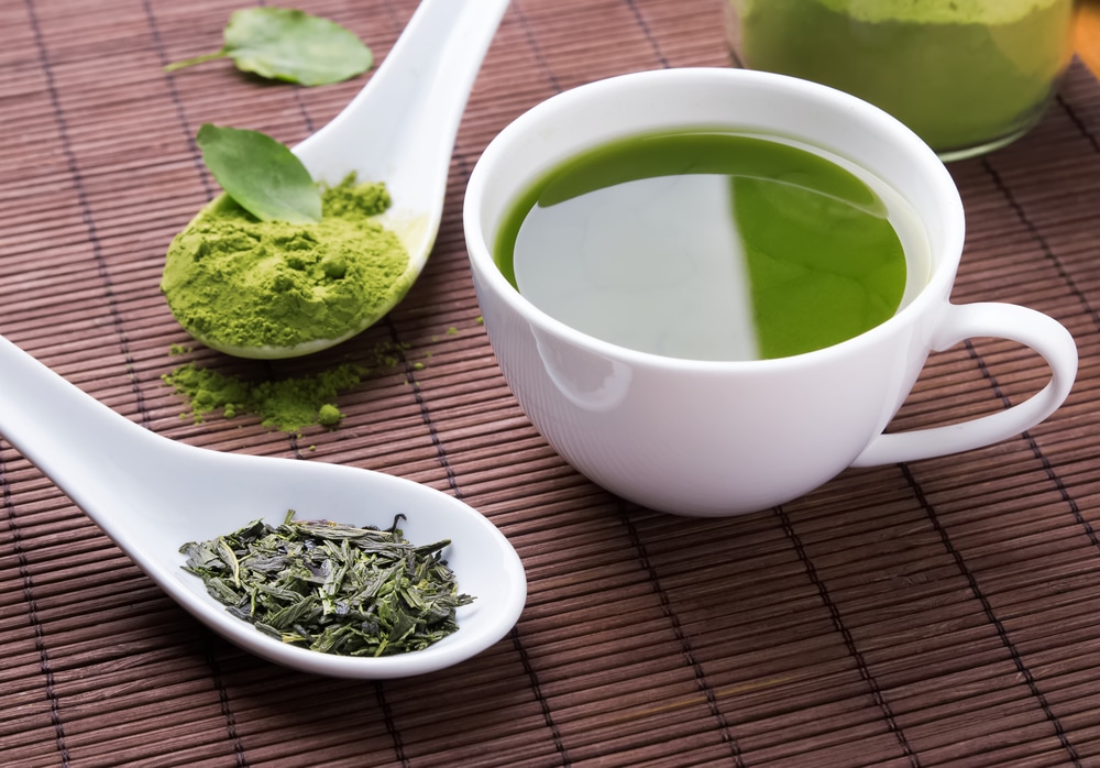 A cup of green tea on a wooden table.