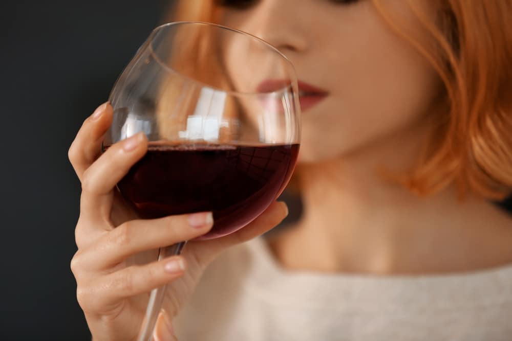 Closeup of a woman drinking red wine.