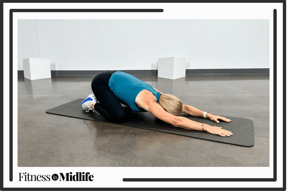 Chris Freytag doing a child's pose on a yoga mat.