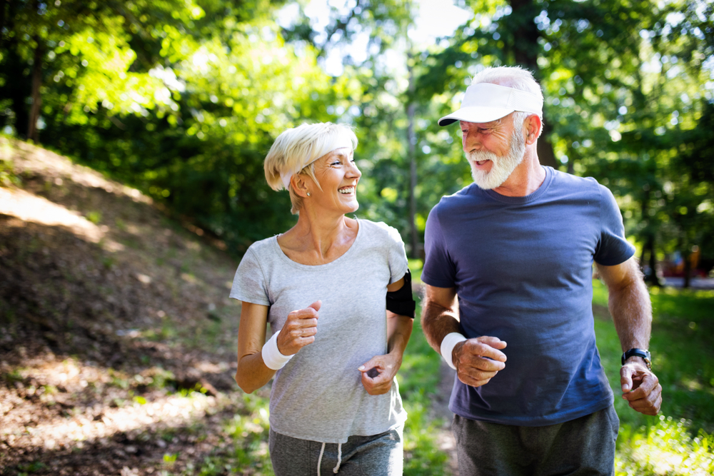 A happy older couple walking in the park.