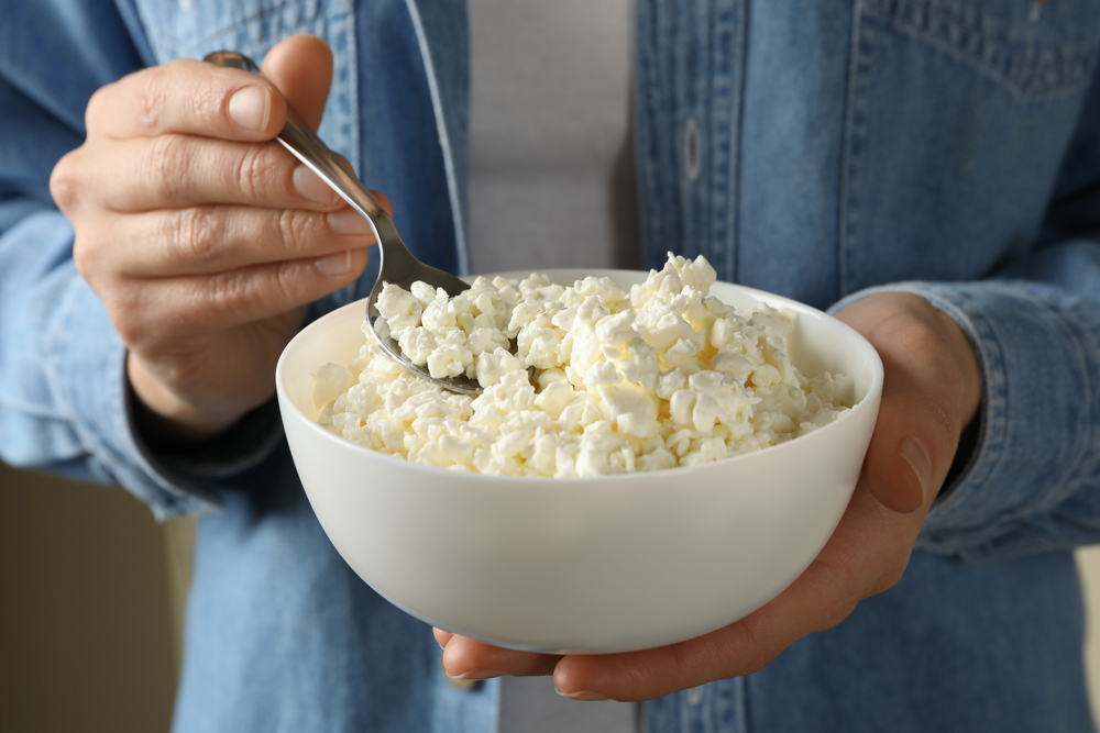 A person holding a bowl of cottage cheese.