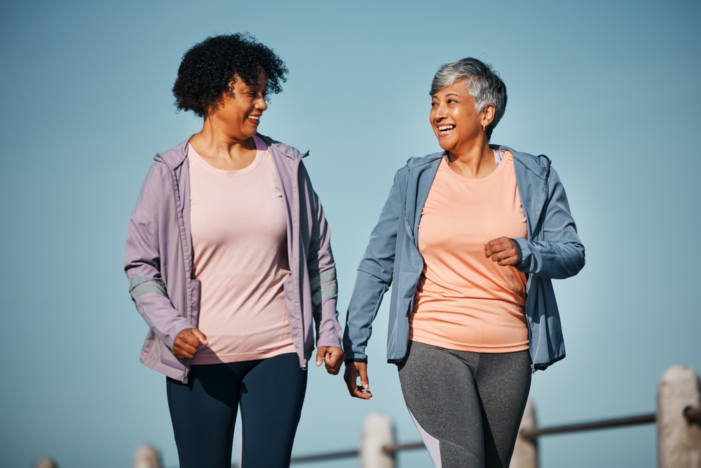 Two happy women walking outside.