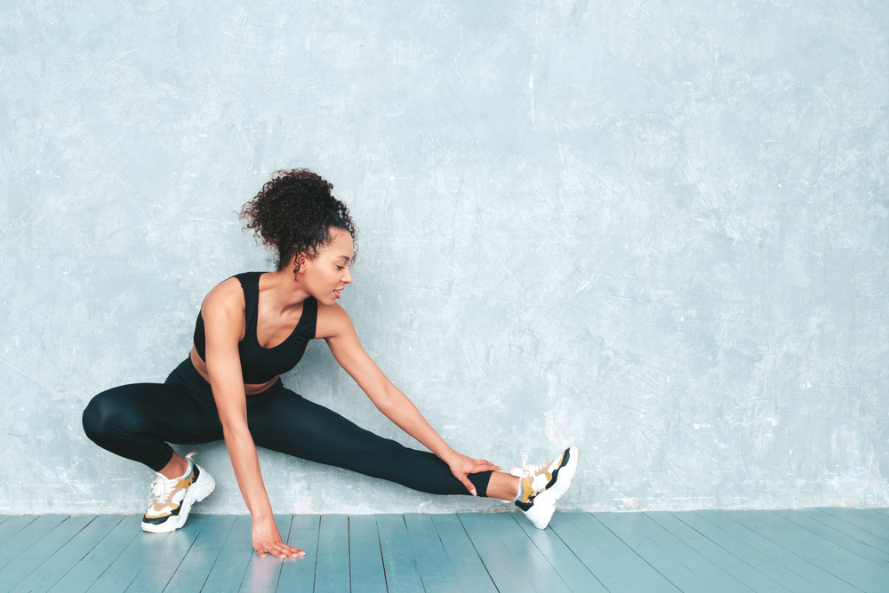 A woman stretching her legs before a workout.