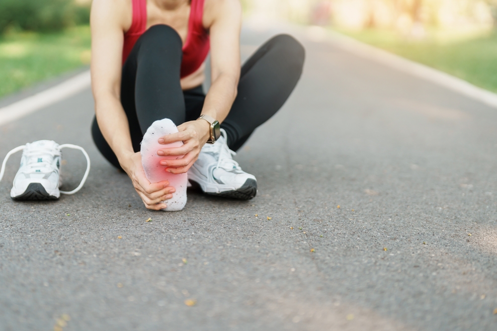 woman holding heel while walking