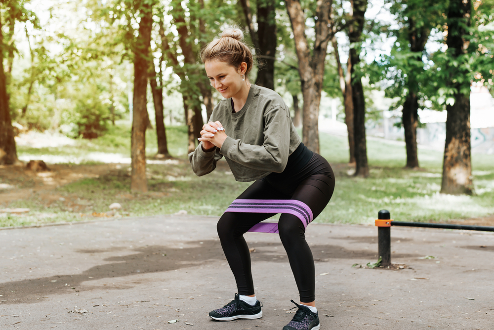 woman using mini resistance band to workout