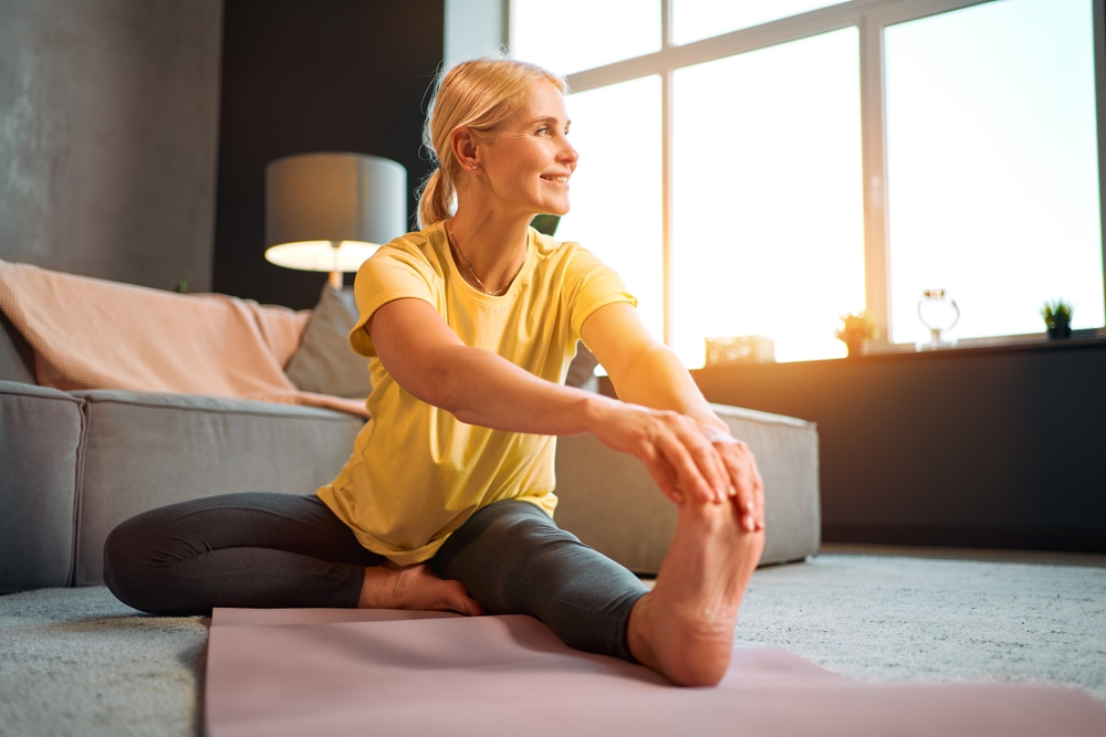 woman doing pilates stretch on mat