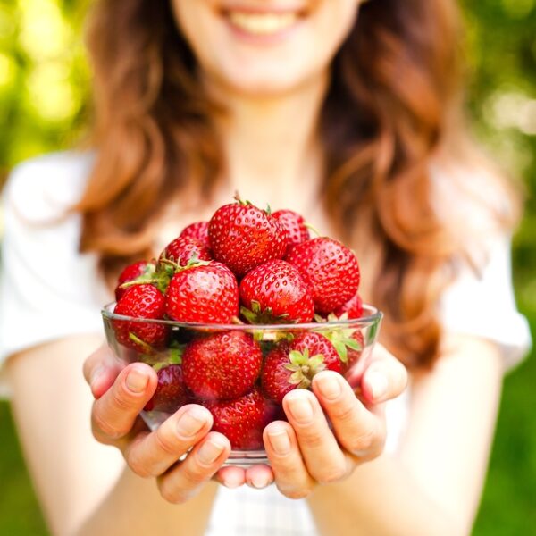 foods that lower blood pressure woman holding strawberries