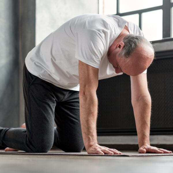 man doing cat pose for back pain