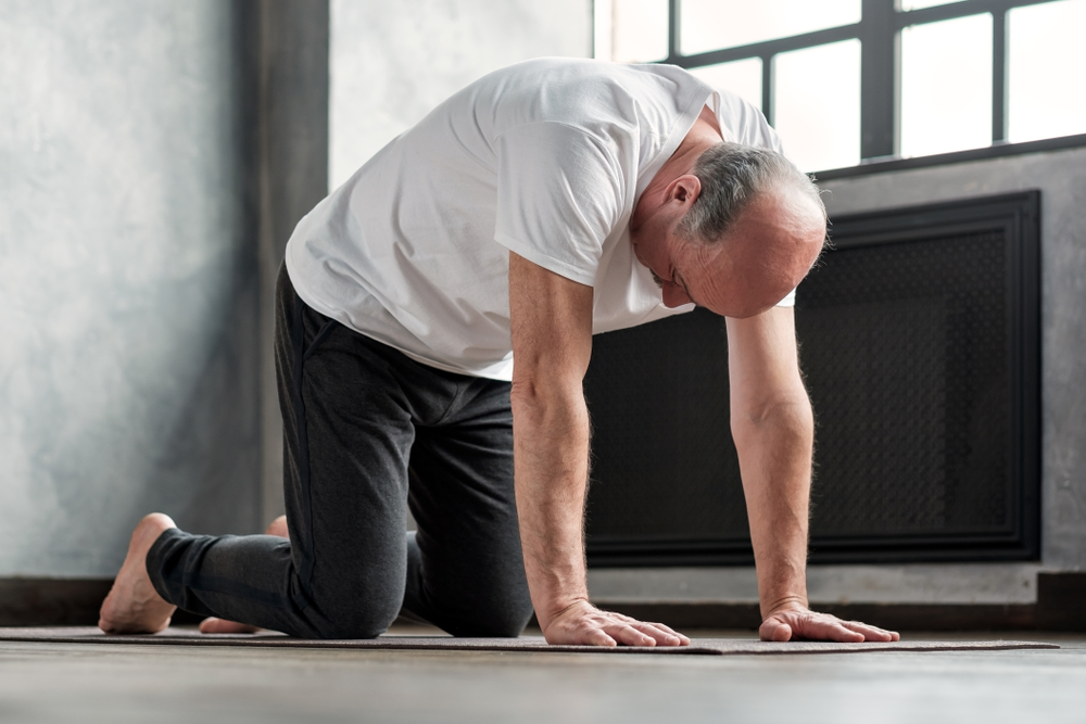 man doing cat pose for back pain