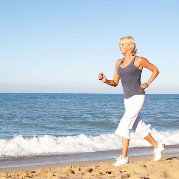 woman running on beach ignoring top women's health challenges