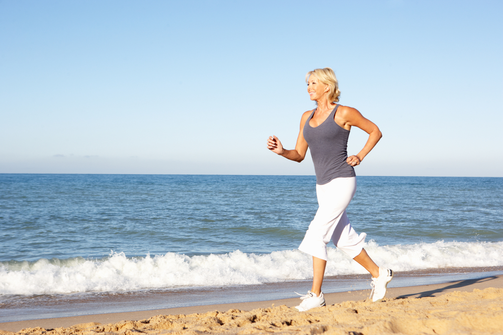 woman running on beach ignoring top women's health challenges
